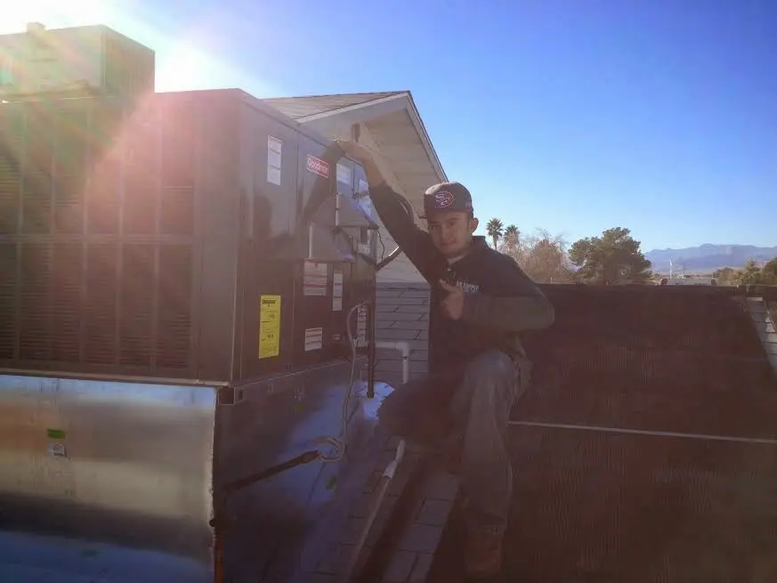 HVAC technician performing AC Tune-Up on a rooftop unit in Sanibel